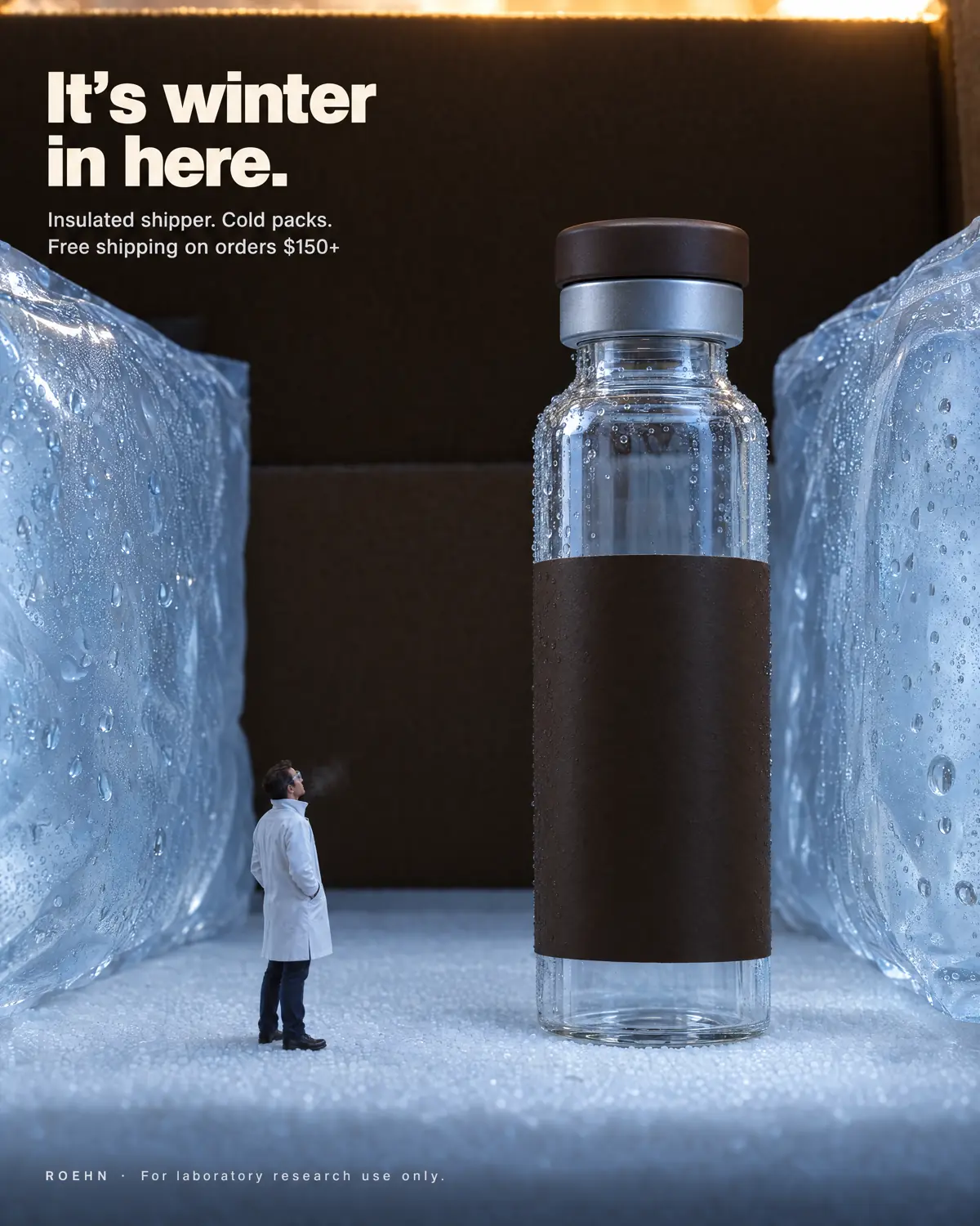 A small figure in a lab coat looks up at an unlabelled vial standing between two cold packs inside an insulated shipper. Text: It’s winter in here. Insulated shipper. Cold packs. Free shipping on orders $150+.